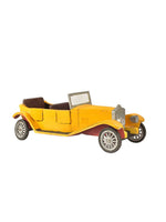 A yellow vintage-style toy car with brown seats, black tires, and silver-colored grille and headlight details, isolated on a white background.
