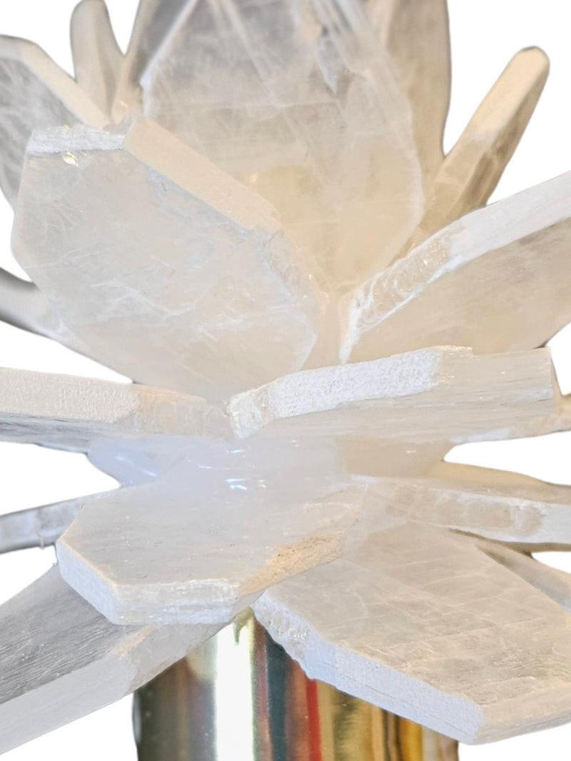 A crystal cluster candle holder featuring a white and clear selenite crystal cluster on a polished metal base, isolated on a white background.