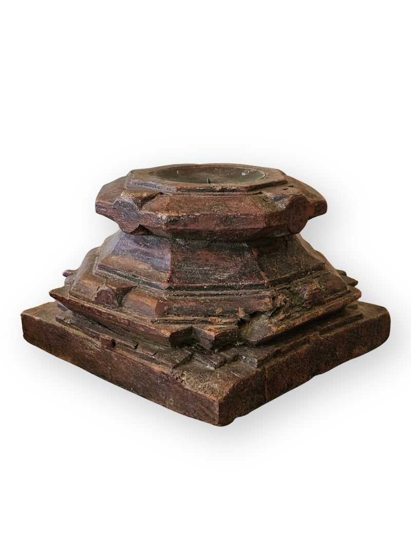 An antique carved wooden pedestal  with a tiered structure and a circular top opening, shown on a plain white background.