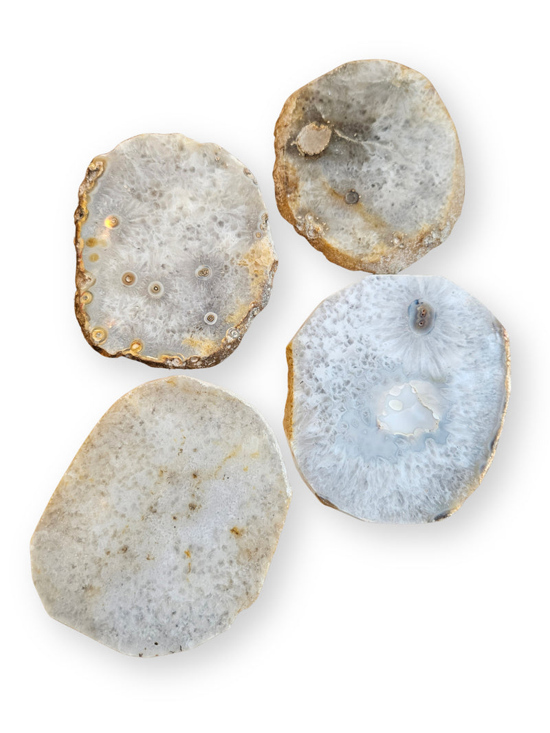 Four natural agate slice coasters with textured crystalline patterns, displayed on a clean white background.