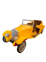 A yellow vintage-style toy car with brown seats, black tires, and silver-colored grille and headlight details, isolated on a white background.