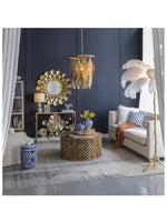 Room with navy walls white furniture gold petal mirror on the wall, a large gold leaf motif chandelier, l 